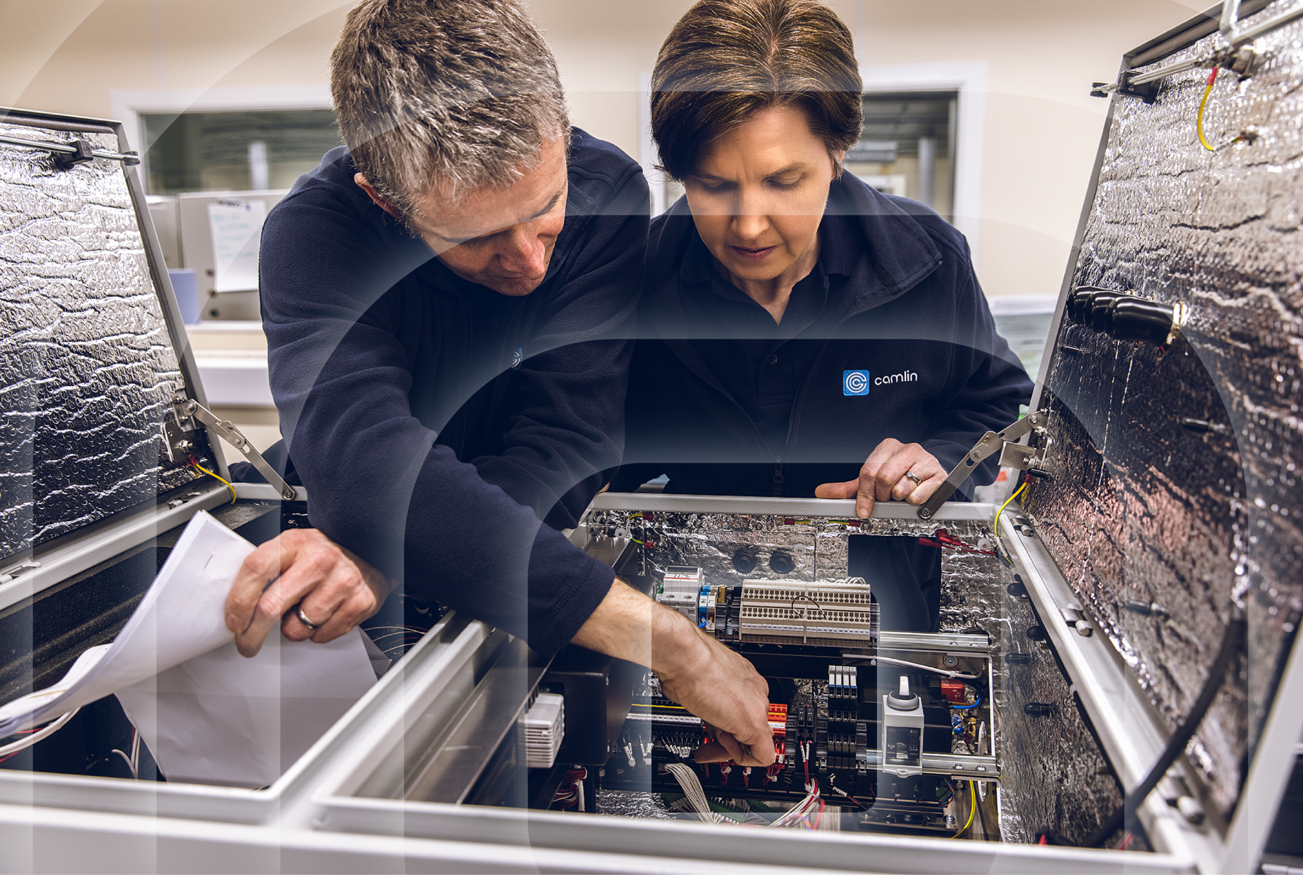Male and female working inside a computer board